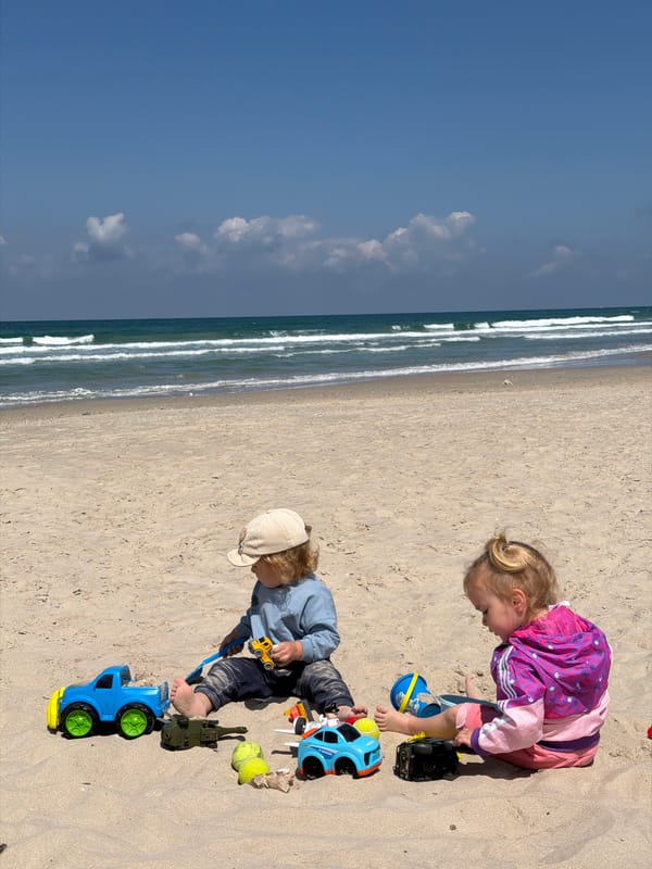 Children play with toys on sunny beach morning