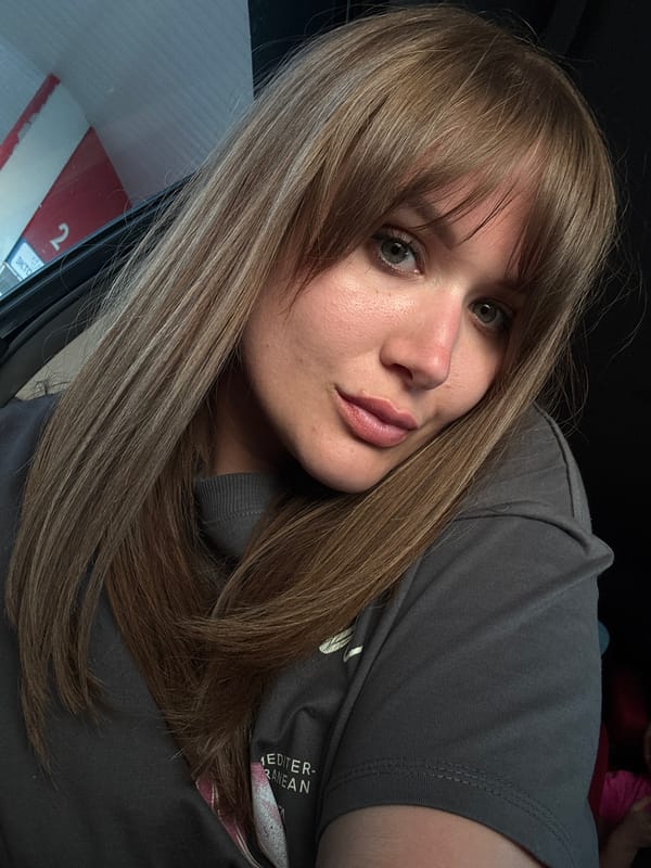 Woman takes selfie, captured in car mirror in Vinogradny