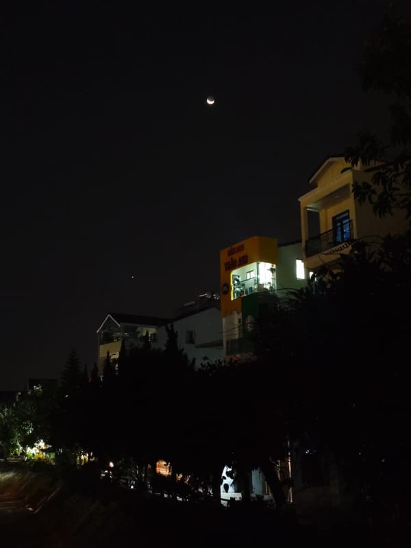 Crescent moon illuminates quiet Da Lat streets during evening hours