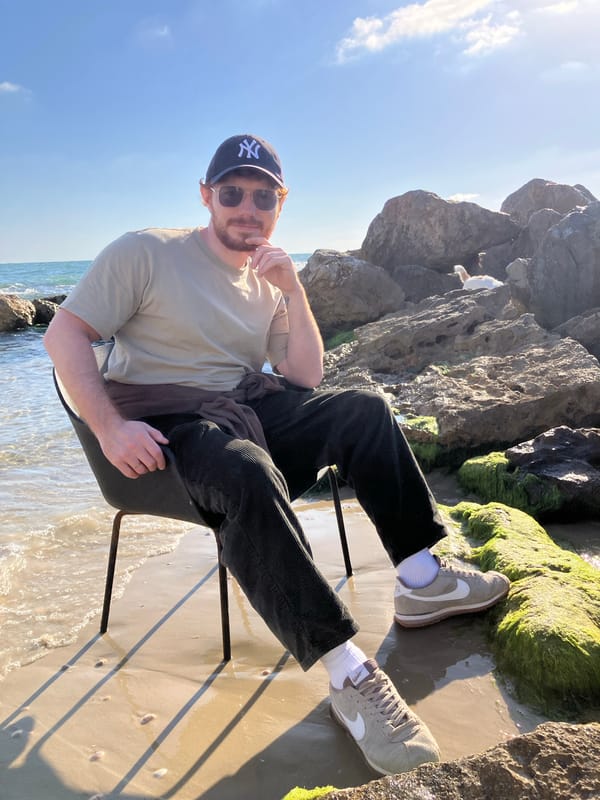 Woman with white dog photographed on stone wall in Bat Yam