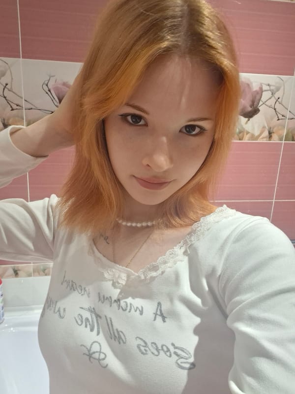 Person in white lace shirt photographed indoors