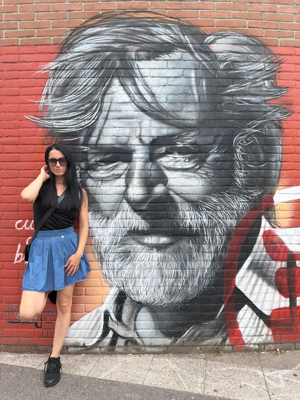 Posing with street art murals on a Corsico brick wall.