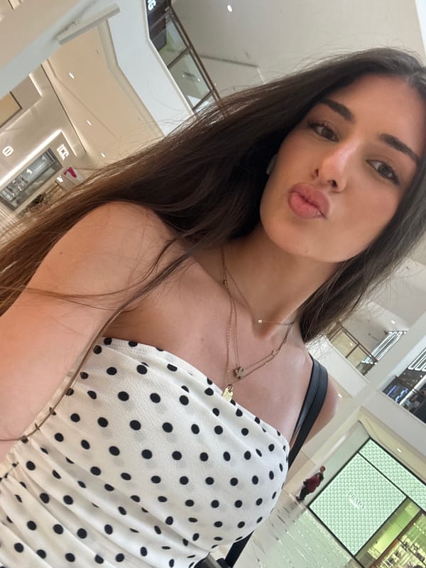 Selfies on a shopping mall escalator in a polka-dot top