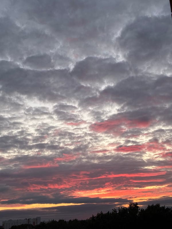 Dramatic sunset sky, clouds lit in pink and orange
