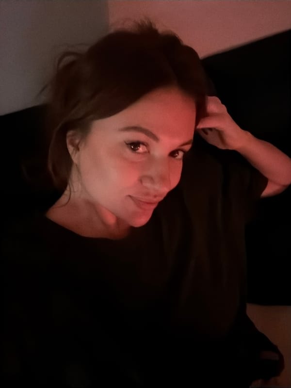 Woman rests in dimly lit Belgrade apartment at night