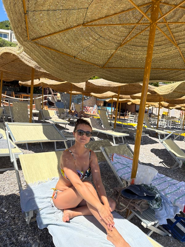 Woman relaxes on shaded beach in Prijevor, Montenegro