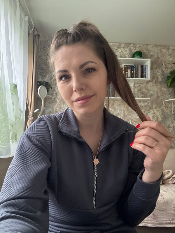 Woman holds hair strand indoors in Razdolye, Russia