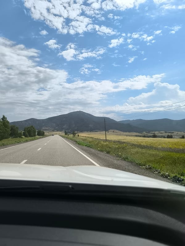 Road trip through rural hills under shifting skies