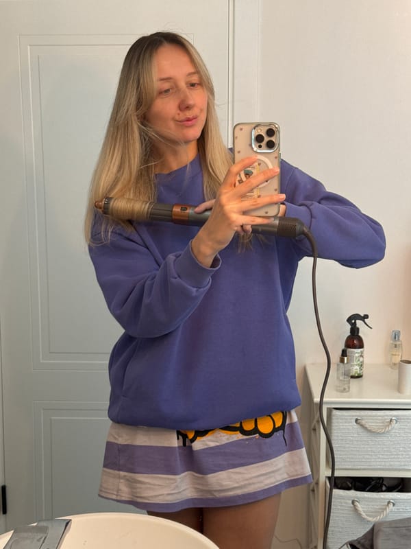 Woman takes selfies while styling hair in Carnikava