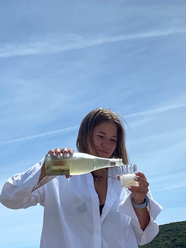 Woman enjoys sparkling wine on Montenegro beach