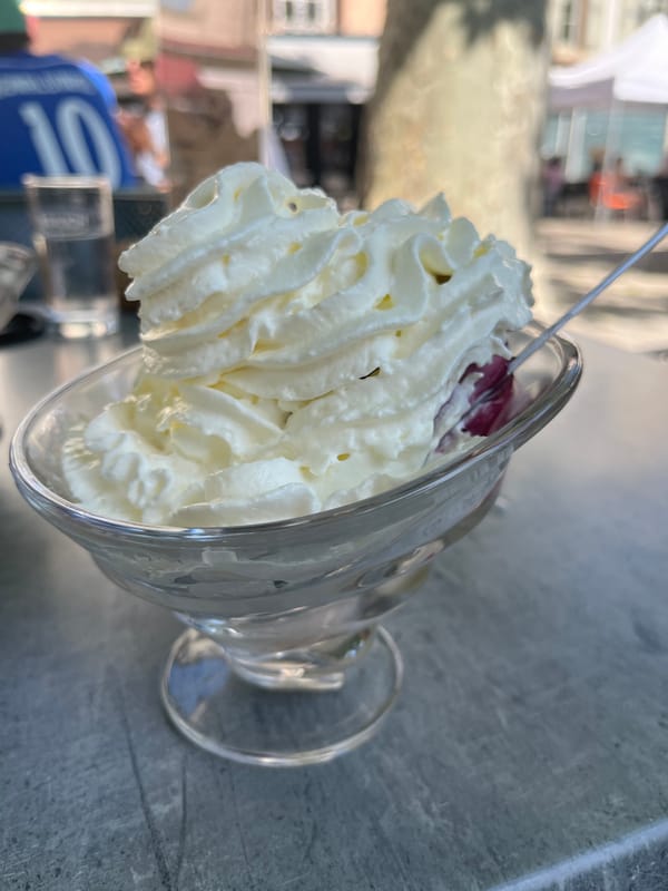 Woman enjoys dessert at outdoor cafe in Montbrison