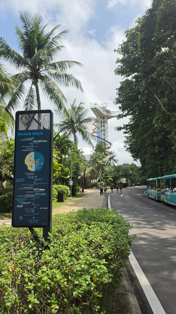 Singapore coastal park path with signage and greenery