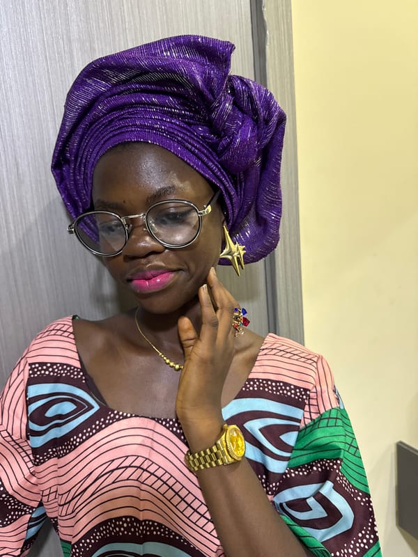 Woman in purple headwrap takes selfies, applies makeup in Nigeria