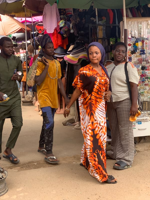 Abuja street market buzzing with vendors and shoppers midday