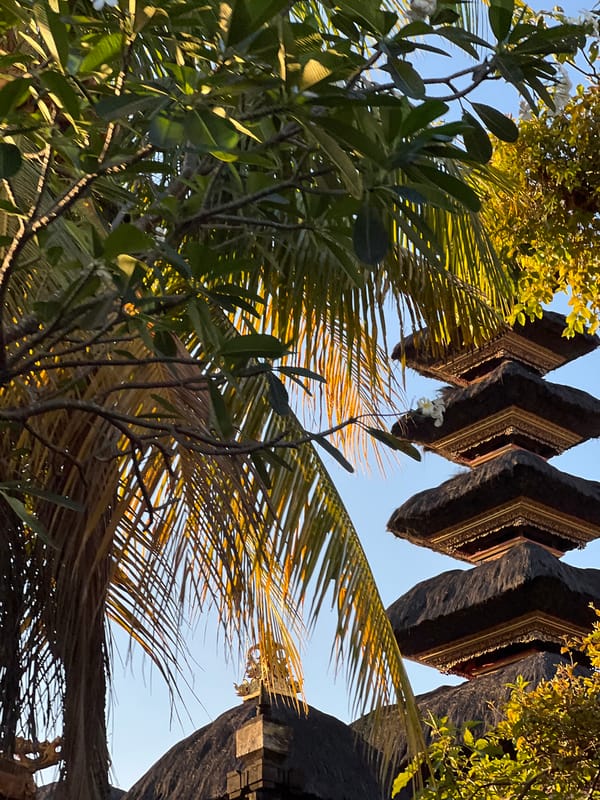 Penjor decorations and a Meru tower along a North Kuta street