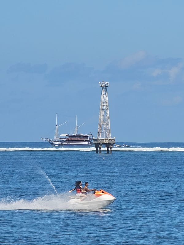 Jet skis and sailing vessels on the water off Bali