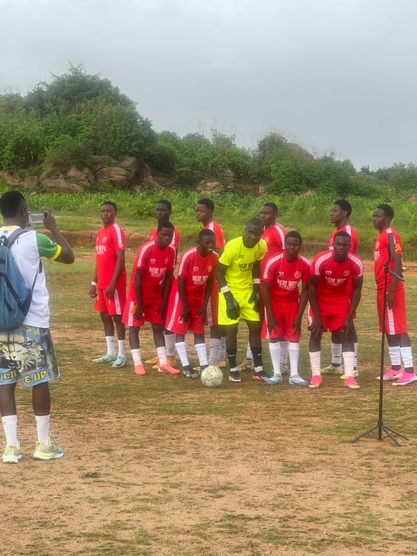Soccer teams assemble on a Jos field before or after a match