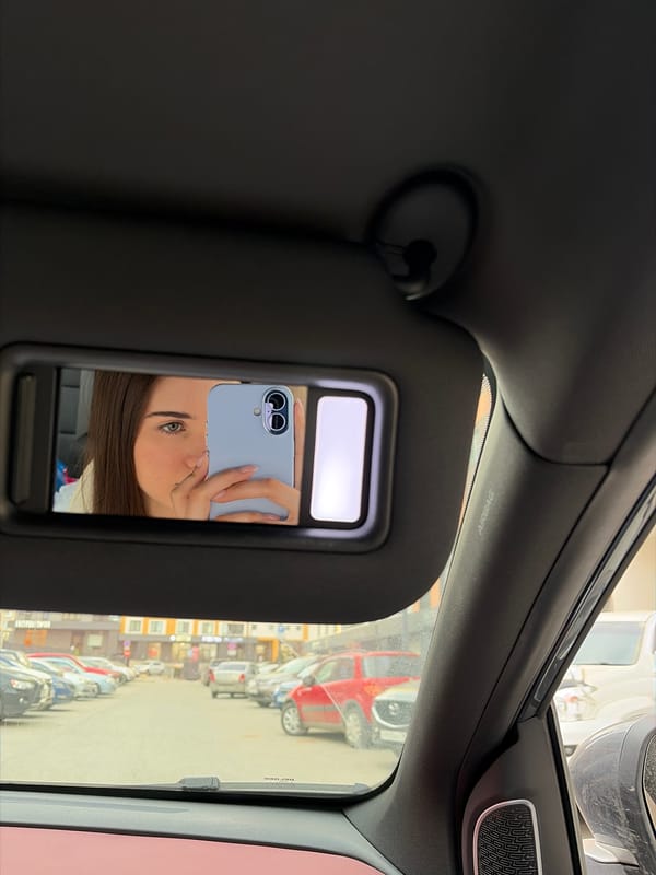 Woman takes playful mirror selfies in car in Izhevsk