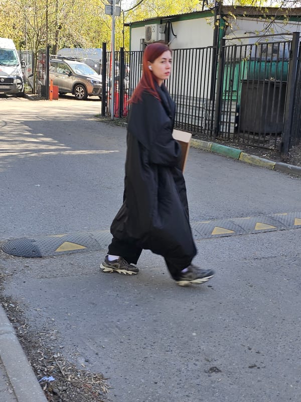 Woman walks Moscow sidewalk near tree stump on sunny day