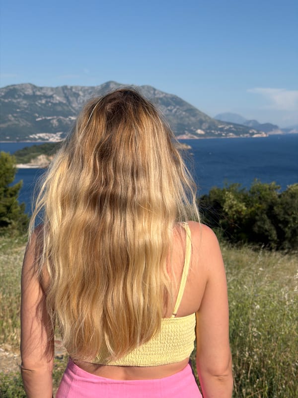 Woman in yellow and pink explores scenic Budva viewpoints