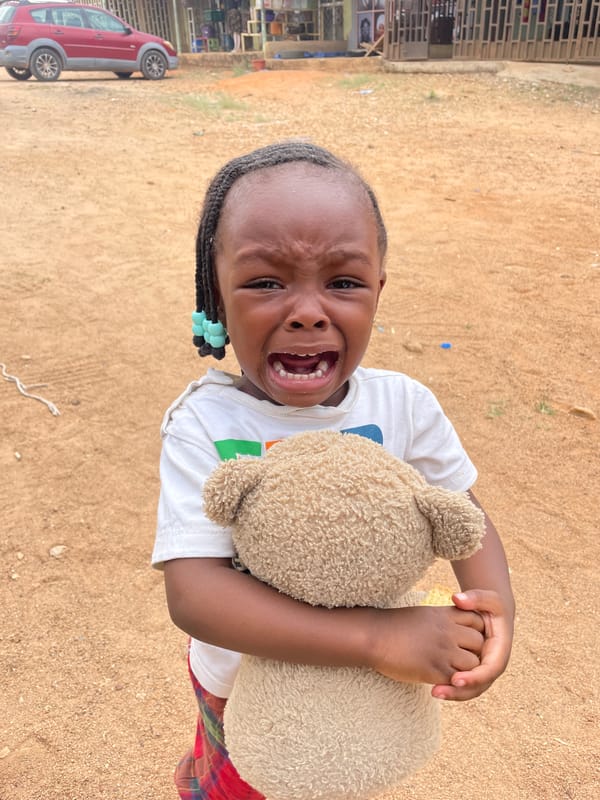 Young child with teddy bear crying in Nigerian village