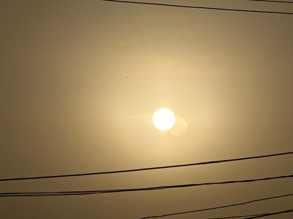Hazy sun observed through smoky atmosphere in urban area