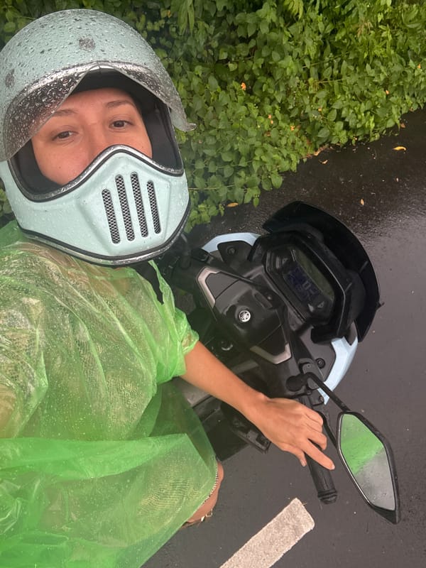 Motorcyclist in raincoat stops roadside in Kuta Selatan