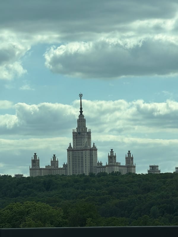 Moscow State University building photographed amid trees and clouds