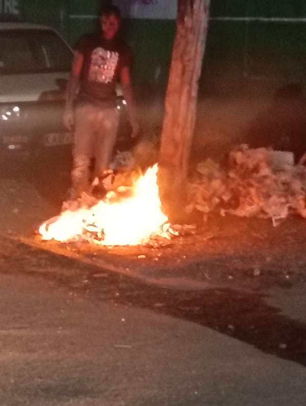 Fire burns on street near trash pile in Nairobi
