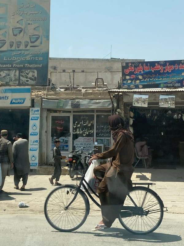 Cycling through Kandahar streets on a mismatched-wheel bicycle