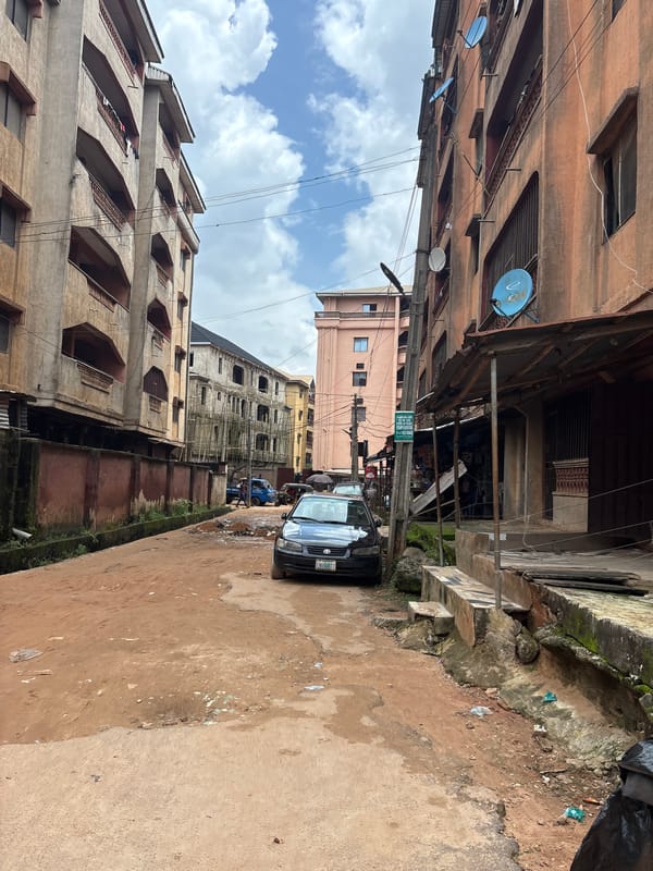 Everyday street life along a potholed Onitsha neighborhood.