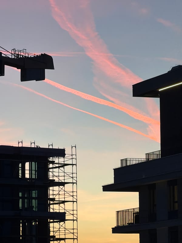 Aircraft contrails spotted over Belgrade buildings during evening hours