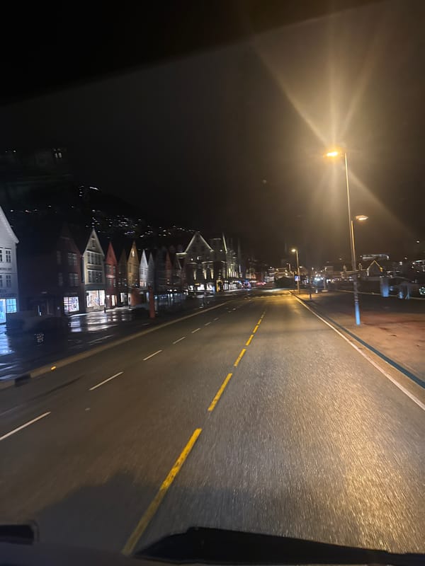 Nighttime street view captures illuminated Bergen waterfront district