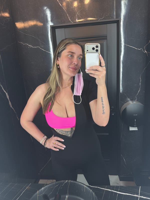 Woman takes selfie in Moscow bathroom wearing athletic attire