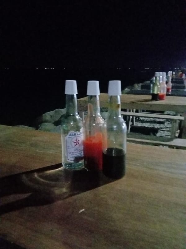 Nighttime coastal gathering captured in Lhokseumawe, Indonesia