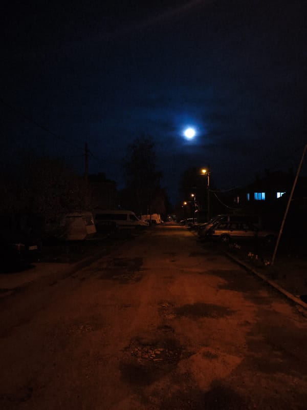 Pothole-riddled street captured under moonlight in Dobrich, Bulgaria