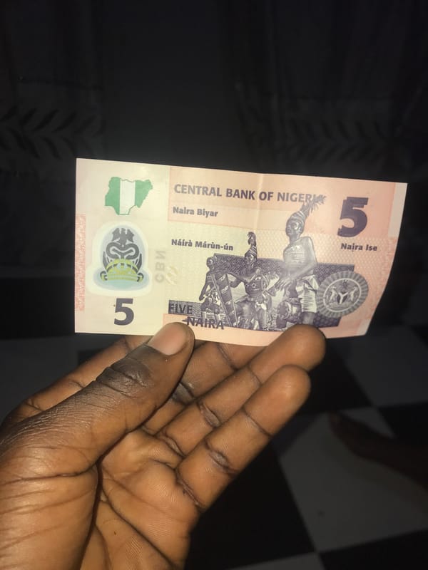 Person holds 5 Naira note and Peak milk on Rukuba Road