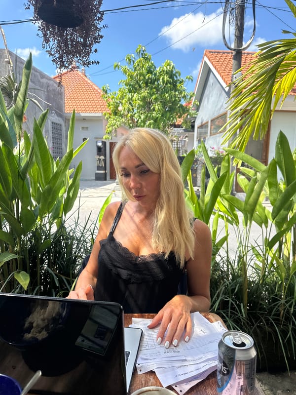 Outdoor laptop session at a plant-surrounded wooden table