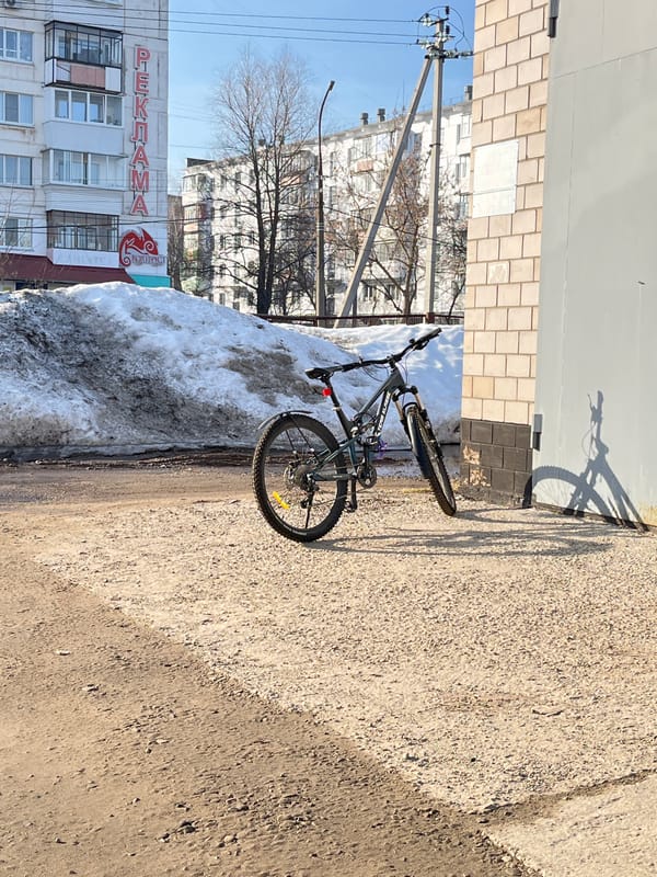 Bicycle parked beside snow pile in Chaikovsky, Russia