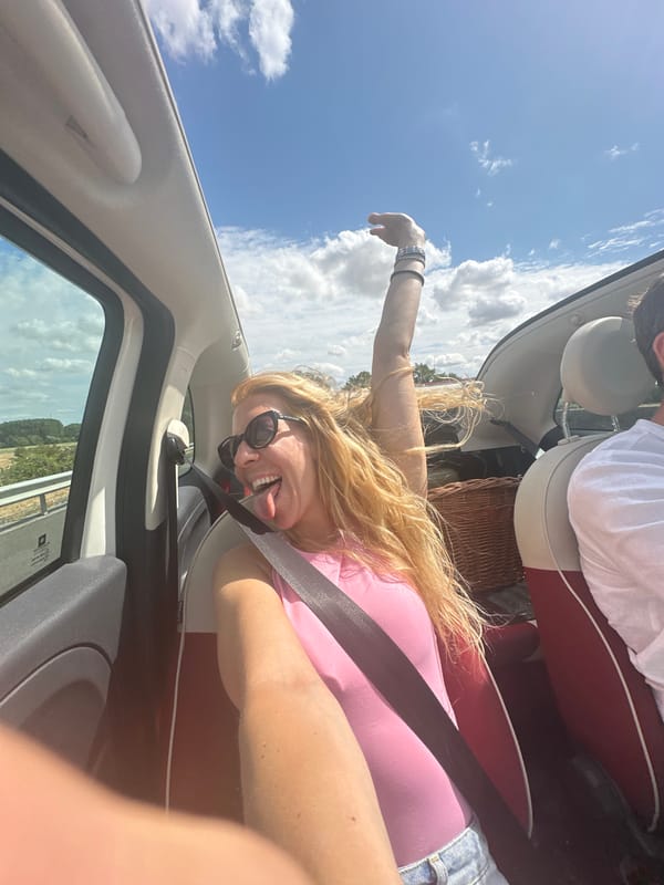 Convertible passenger goofing for the camera on a summer drive