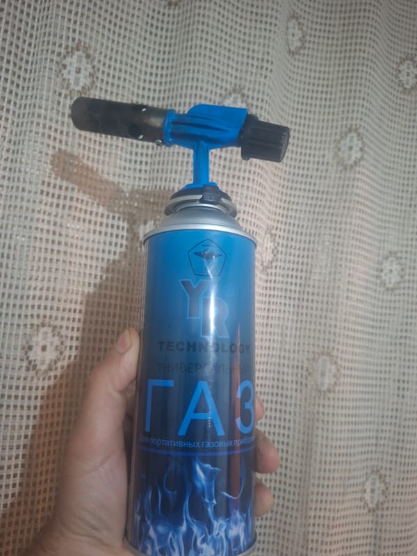 Person displays household items including gas canister, tea, coffee