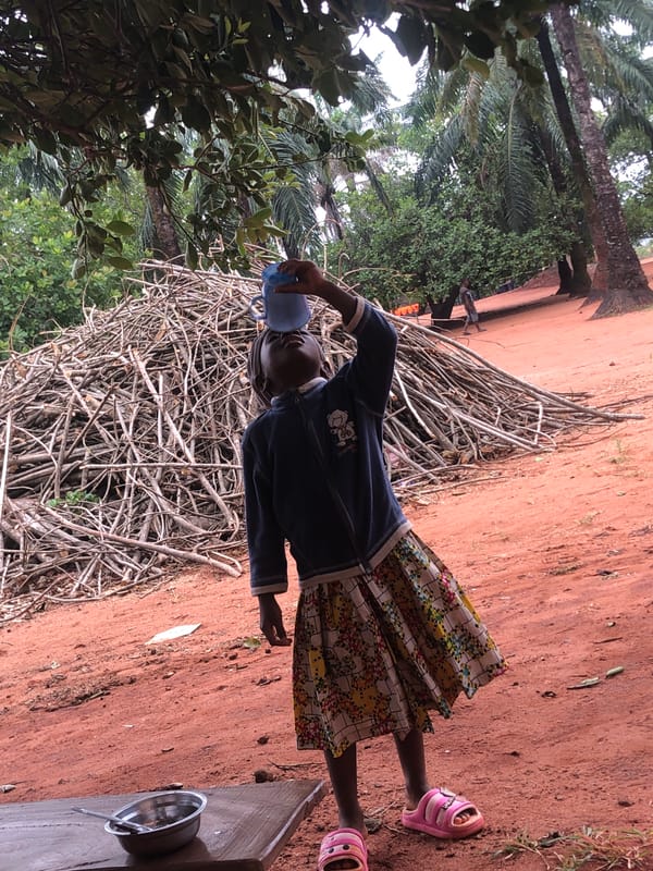 Young girl with blue cup photographed in Nteje, Nigeria