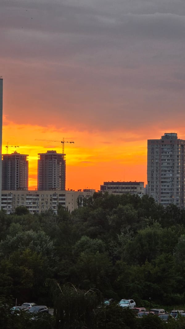 Kyiv sunset frames unfinished high-rises in orange light