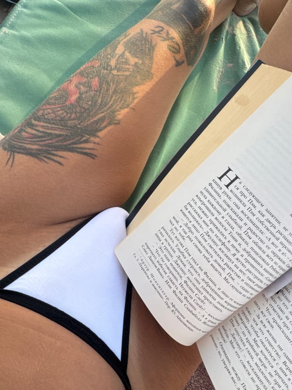 Afternoon beach read, tattoos and Russian book on a lounge chair