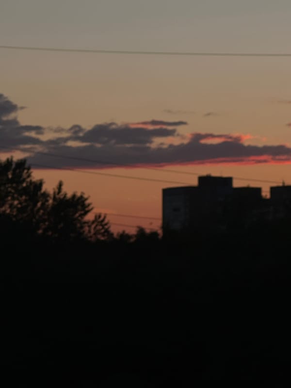 Sunset over Shushary's skyline, pylons and apartments in silhouette