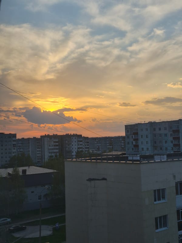 Mixed urban observations: sunset cityscape and Cyrillic whiteboard documented