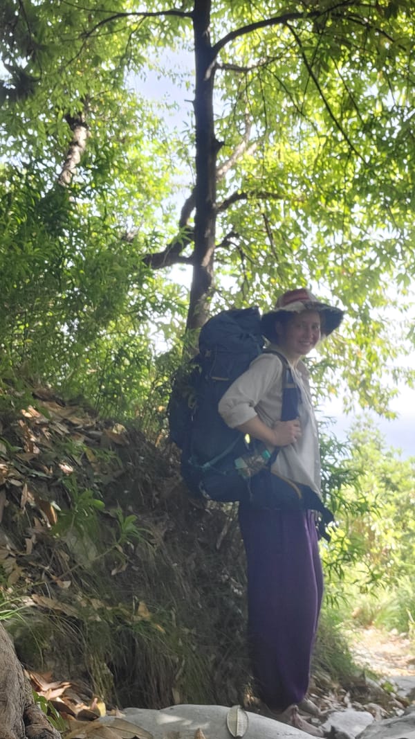 Young person with backpack observed standing outdoors in Haini