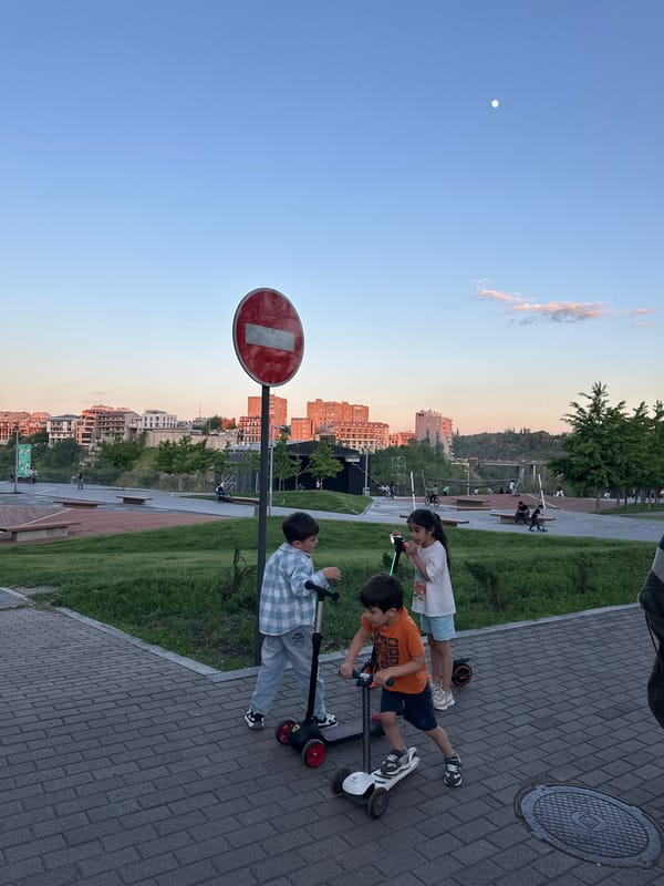 Children play on scooters in sunny Yerevan neighborhood
