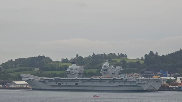 Naval vessels including aircraft carriers observed in harbor