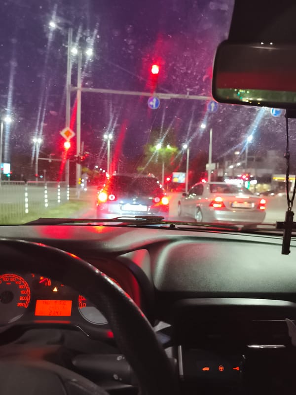 Night drive through Plovdiv, stopped at a rain-slicked intersection